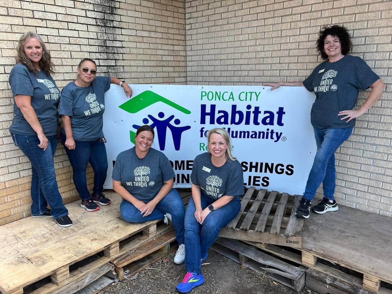 Five Habitat ReStore volunteers with the Ponca City Habitat ReStore sign