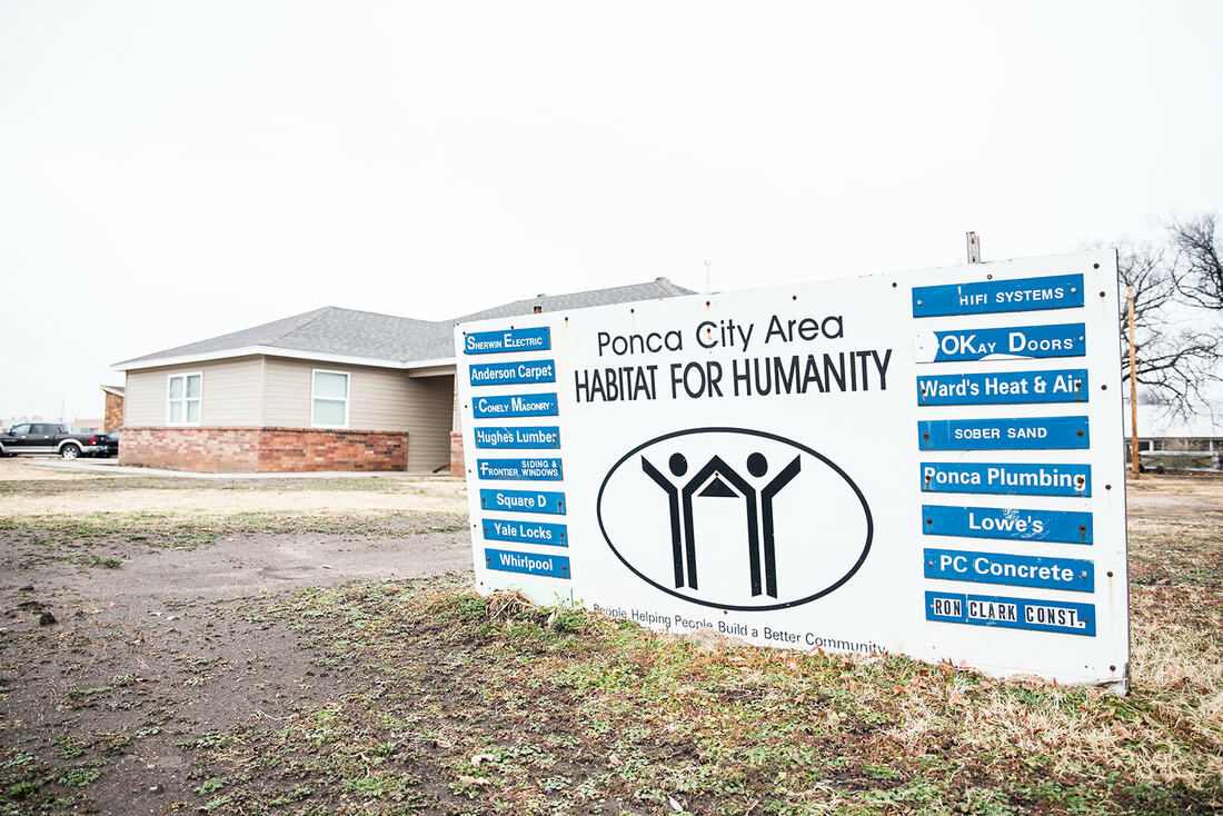 A Ponca City Area Habitat for Humanity home beside its sponsor sign